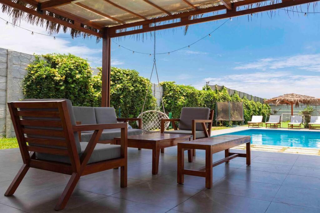 SunampeSOLARIUM CHINCHA Casa de Campo y Playa de 1000mts!的一个带桌椅的庭院和一个游泳池