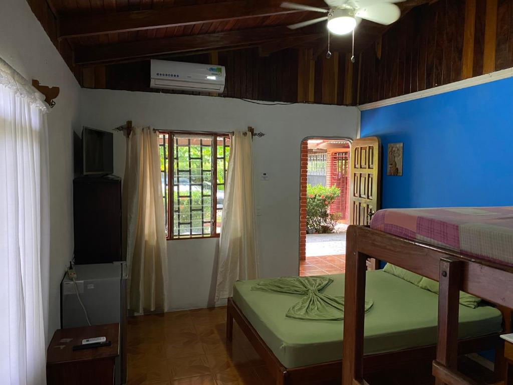 希门尼斯港Corcovado Hostel的一间卧室配有一张床、一台电视和一个窗口