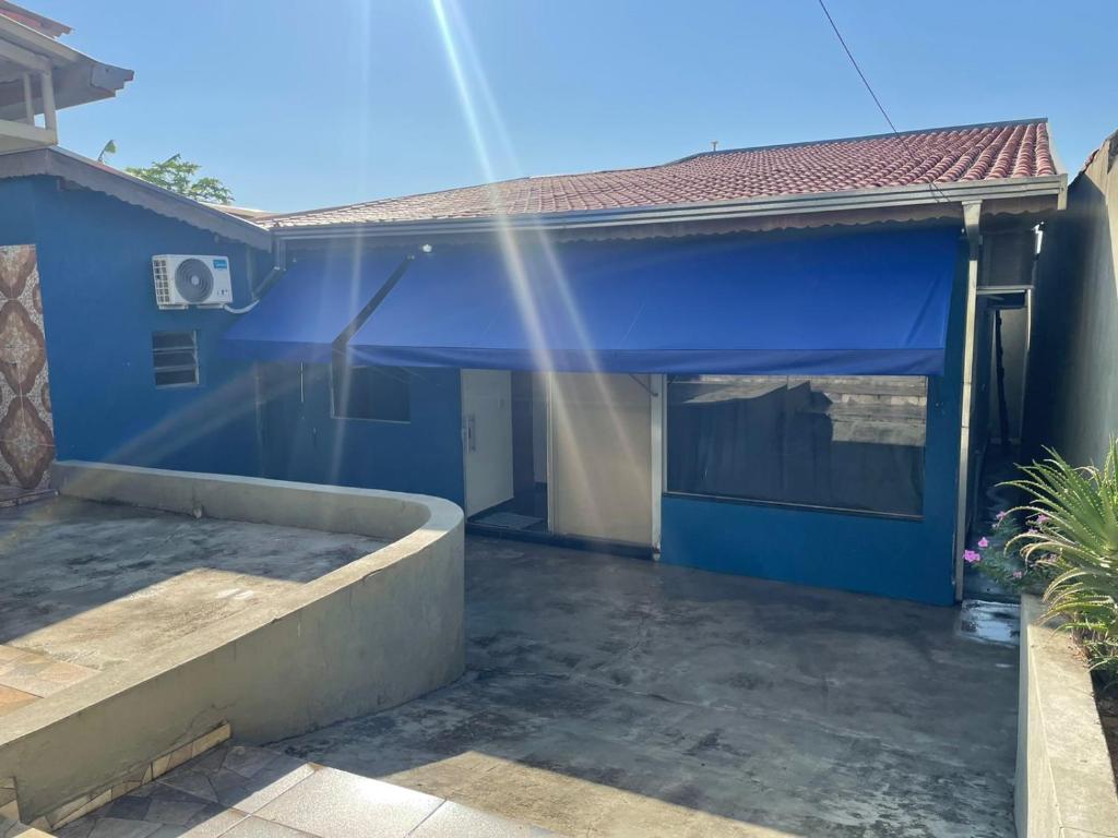 维拉可波斯Pousada Aeroporto Viracopos Campinas的一座房子,里面设有蓝色的车库,阳光灿烂