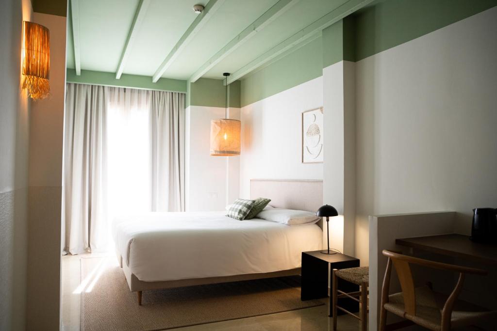 坎佩略Rooms by JovA的卧室配有白色的床和窗户。