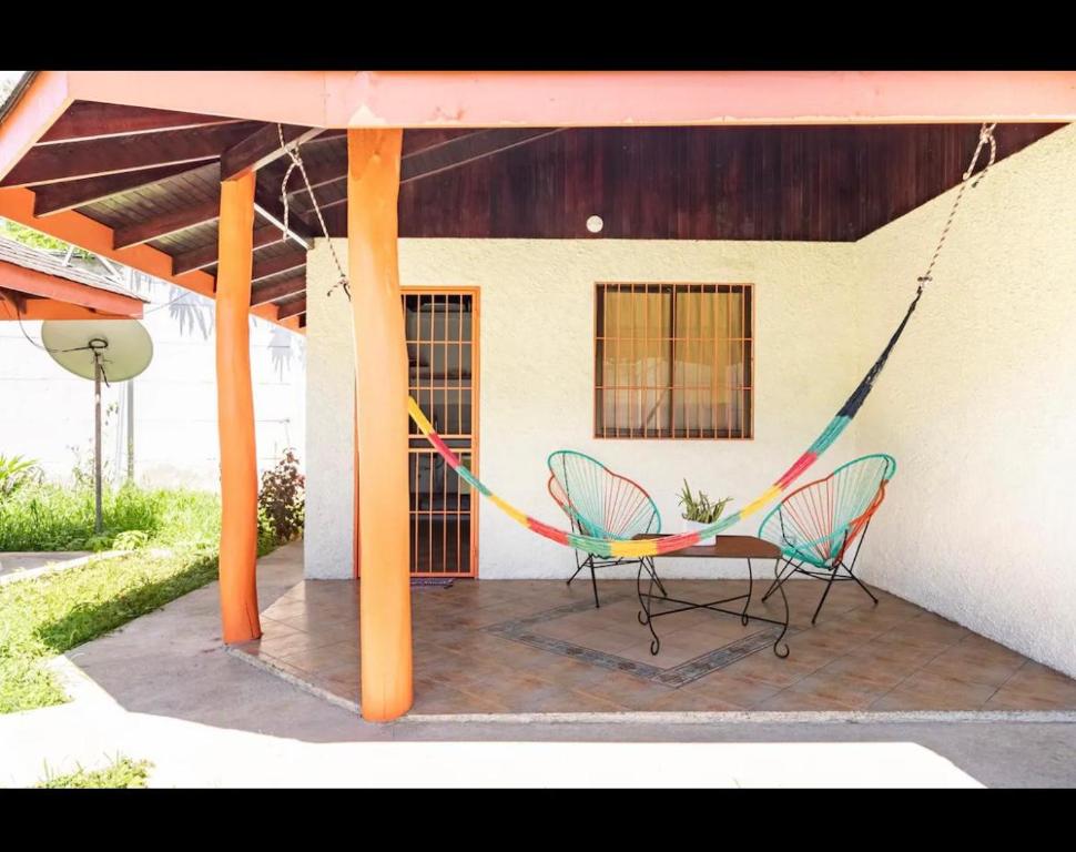 卡维塔bungalow cactus frente ala playa的庭院设有两把椅子和一张吊床