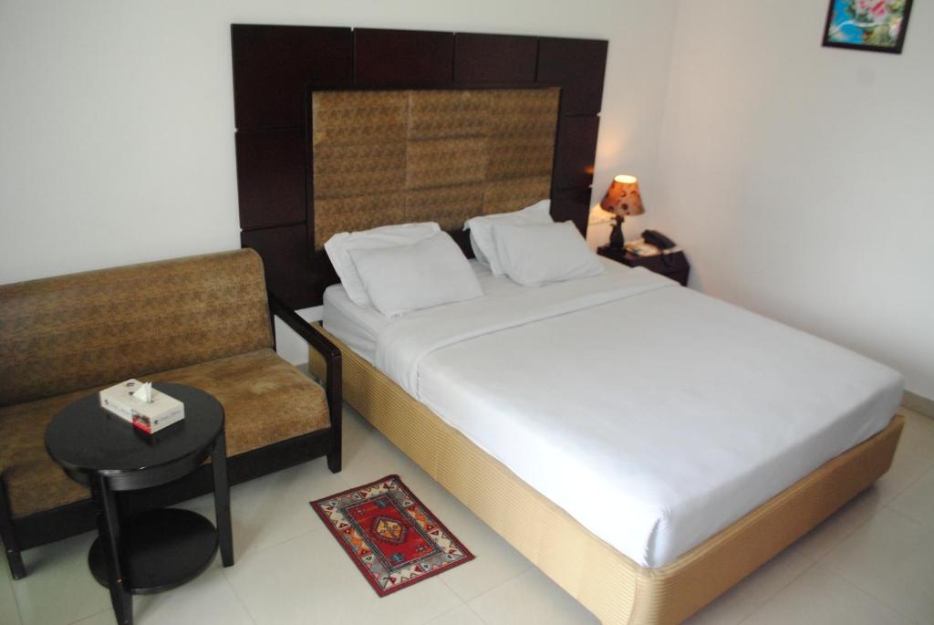 库克斯巴扎密舒克酒店的一间小卧室,配有一张床和一把椅子