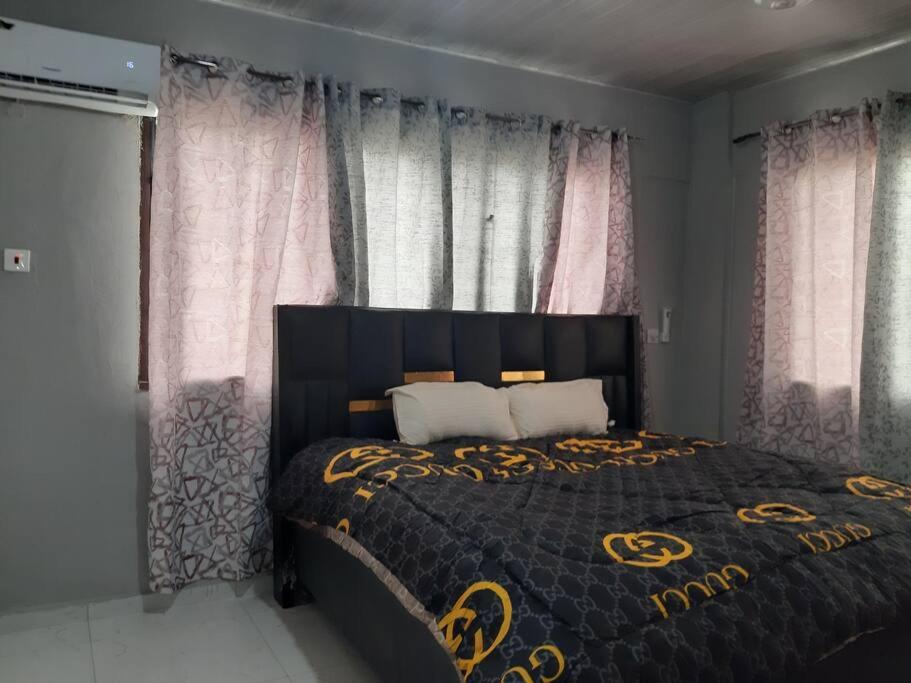 特马The Alpha residence的一间卧室配有一张带黑色和金色床罩的床。