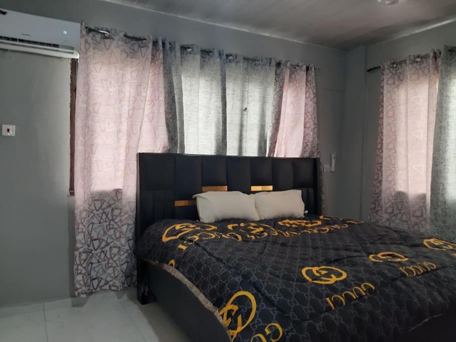 特马The Alpha* residence的一间卧室配有一张带黑色和金色床罩的床。