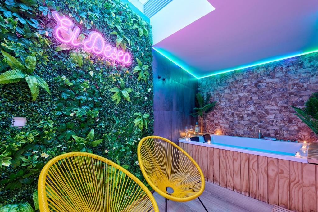 苏埃罗斯El Deseo的浴室设有绿色墙壁、浴缸和2把黄色椅子