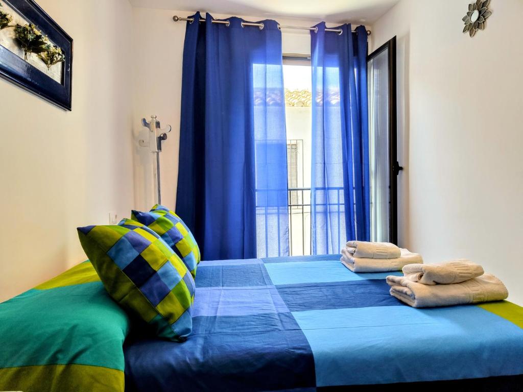 苏埃罗斯El Balcón de Zuheros的一间卧室配有一张蓝色的床和窗户