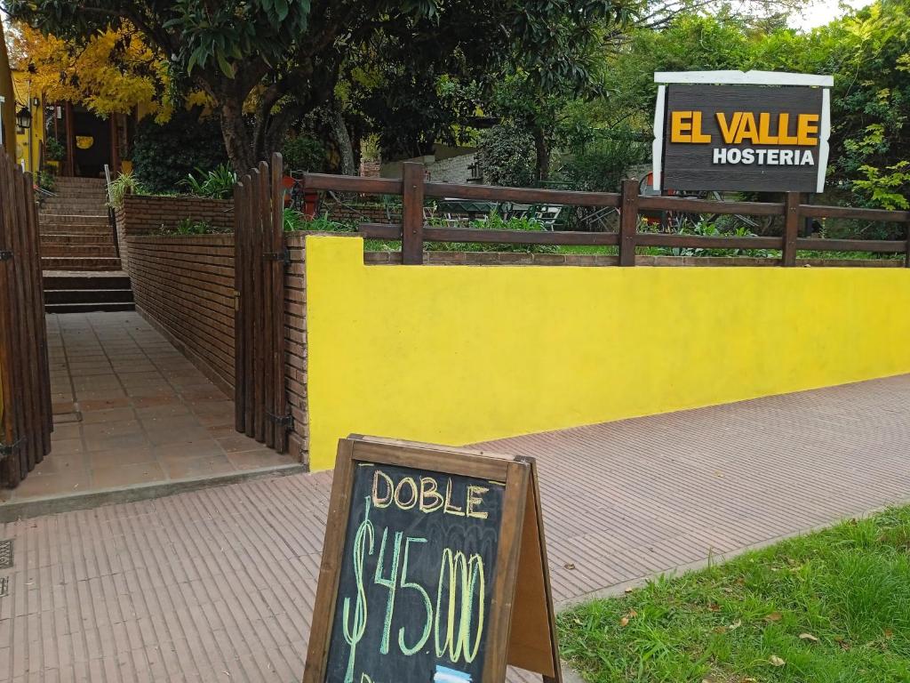 米娜克拉韦罗El Valle Hostería的黄色的墙,上面标有“十二指十二指十二”的标志