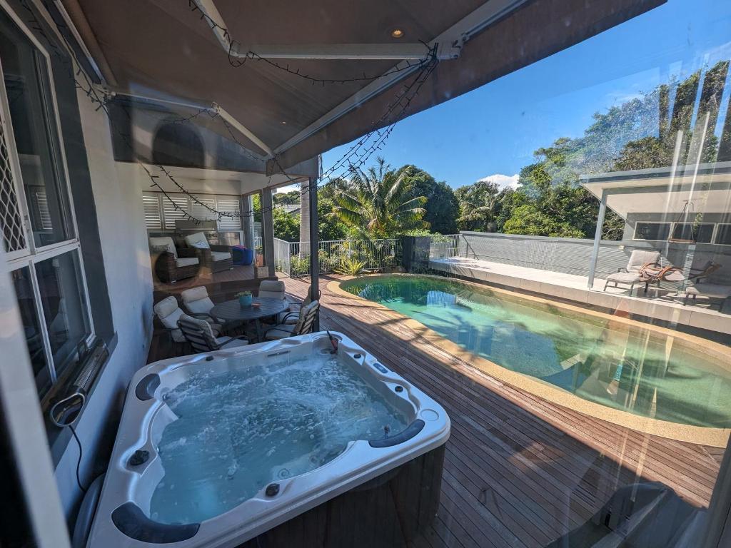 麦夸里港Luxury oasis resort Pet friendly apartment with private pool and spa的游泳池旁甲板上的浴缸