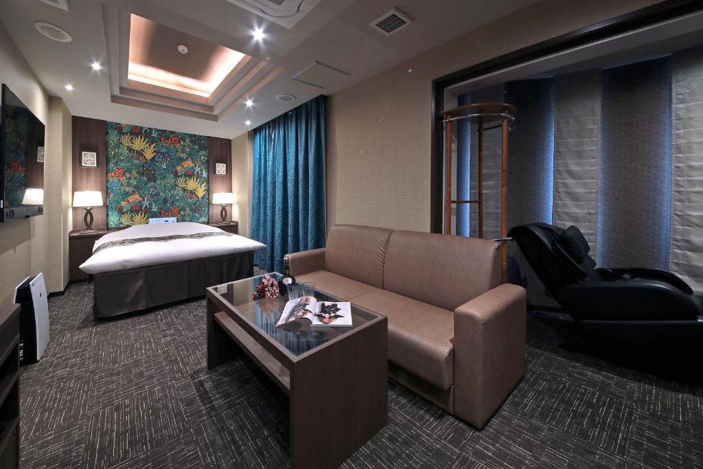 名古屋M'z HOTEL的酒店客房设有一张沙发和一张床