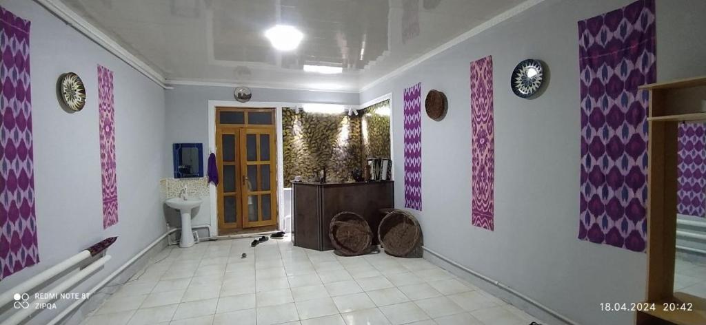 希瓦Khiva Saodat Guest House的一间设有走廊的客房,拥有紫色和白色的墙壁
