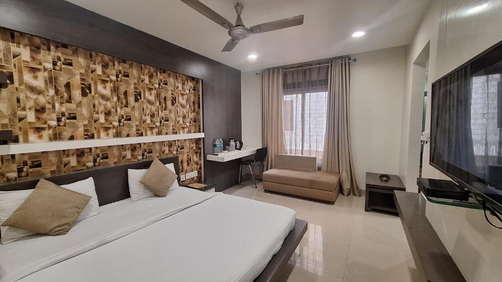 博帕尔Hotel Alankar Palace的卧室配有一张白色大床和电视。