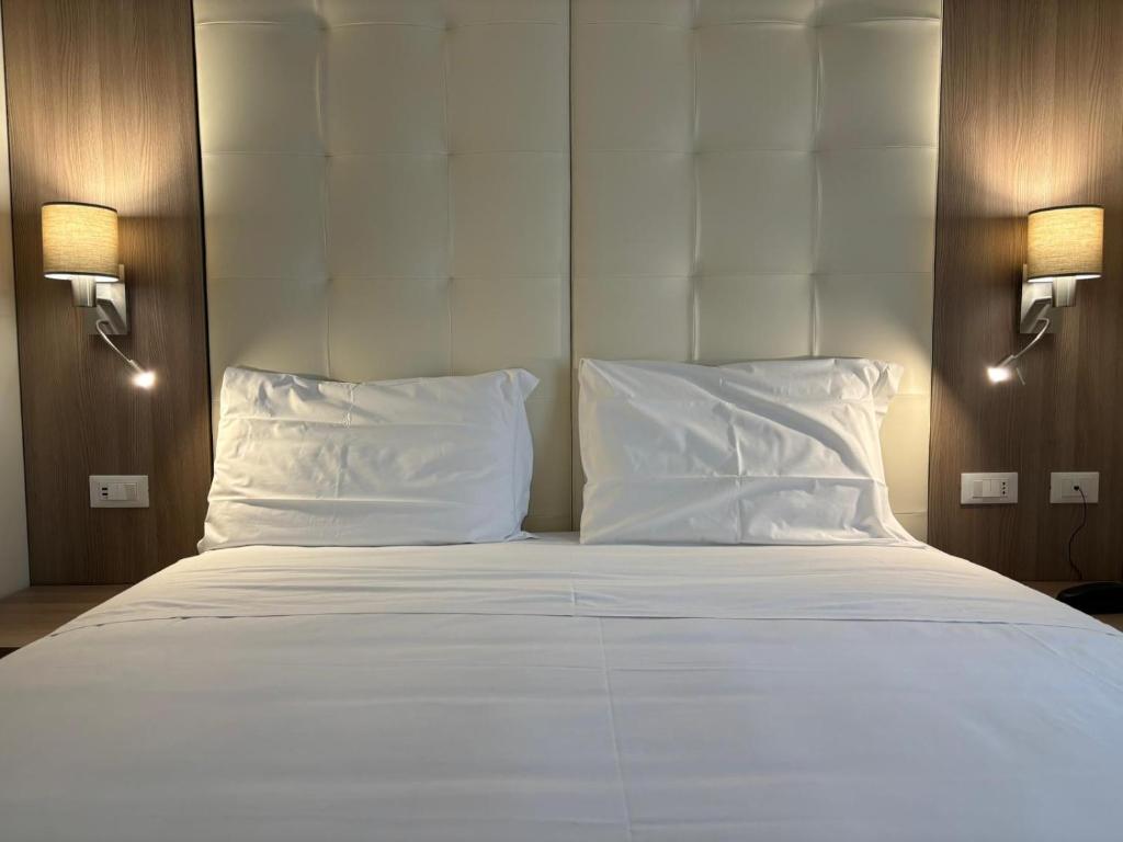 热那亚博卡西纳酒店的一张配有白色床单和枕头的大床