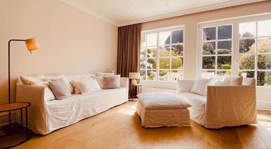 凯图姆Reethus Keitum的客厅配有白色沙发和大窗户