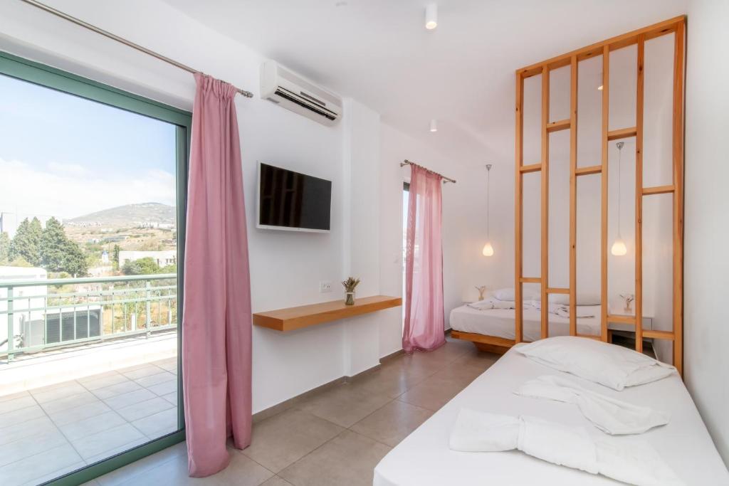 提诺斯Ageri Hotel的一间卧室设有两张床和大窗户