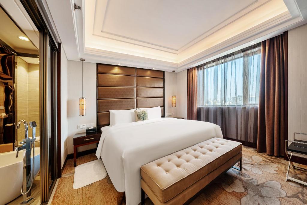 上海上海粤海酒店 的卧室设有一张白色大床和一扇窗户。