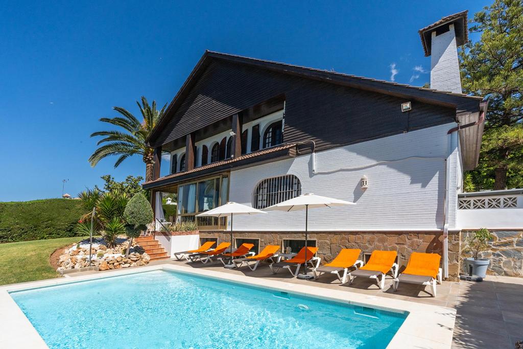 马贝拉Casa El Maizal的别墅 - 带游泳池和橙色椅子