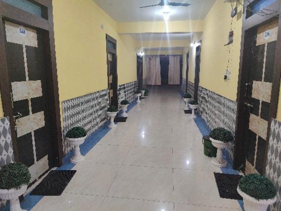 RāmgarhHotel Shobha的楼内带有盆栽的走廊