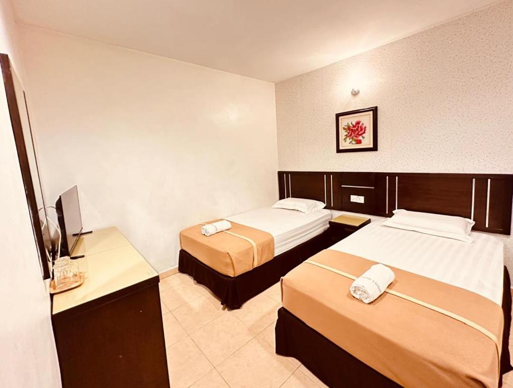 阿罗士打彩虹酒店的酒店客房设有两张床和电视。