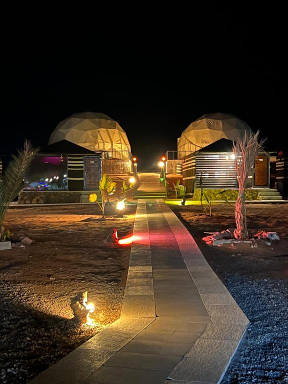 瓦迪拉姆Revan Rum Luxury Camp的夜间两个圆顶前的走道
