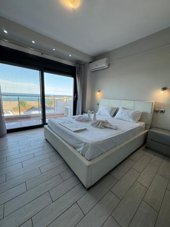 帕拉利亚卡泰里尼斯Aqua Mare Luxury Apartments的一间卧室设有一张大床,享有海景