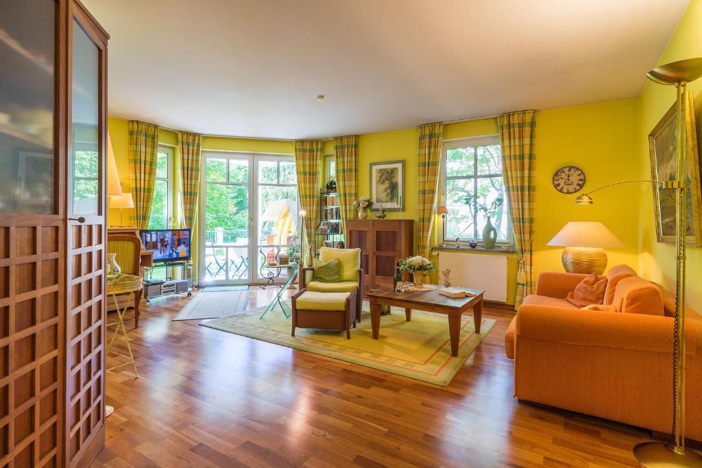 黑灵斯多夫Villa Charlotte App_13的客厅设有黄色的墙壁、一张沙发和一张桌子