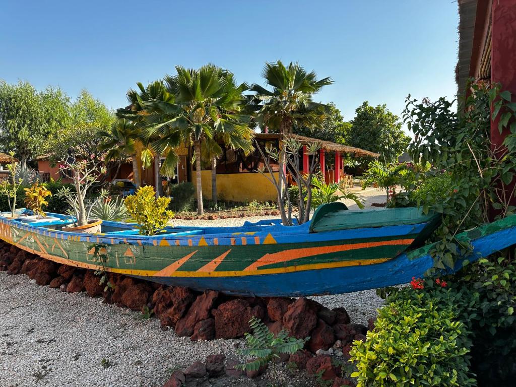 MbodièneMariama Lodge的坐在房子边的大木船