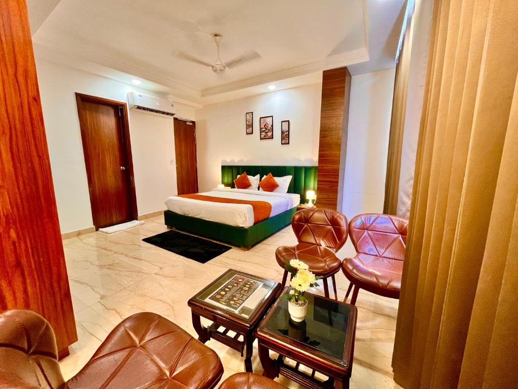 阿姆利则Hotel La Casa Amritsar Near ISBT & Golden Temple的酒店客房,配有一张床和一些椅子