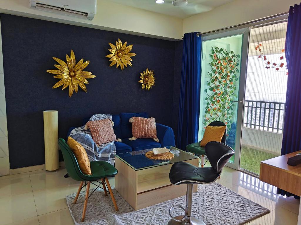诺伊达Sandal suite by Mulberry Homestays的客厅配有蓝色的沙发和椅子