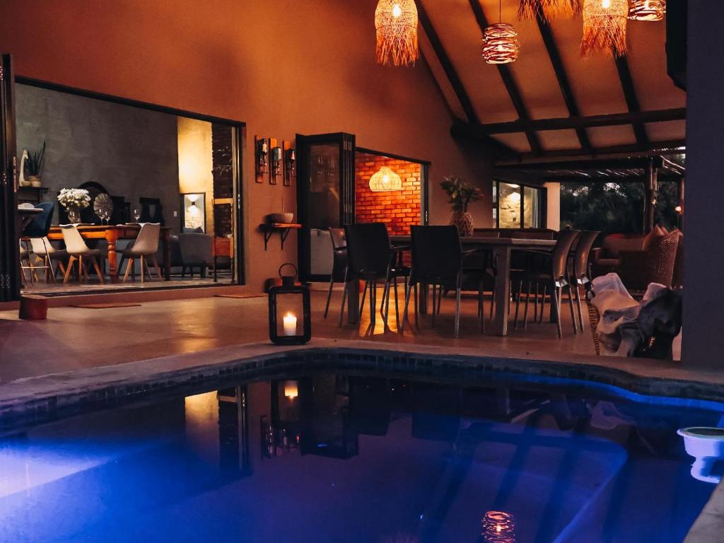 侯斯普瑞特Rhino's Rest Luxury Villa的一座带游泳池和用餐室的房子