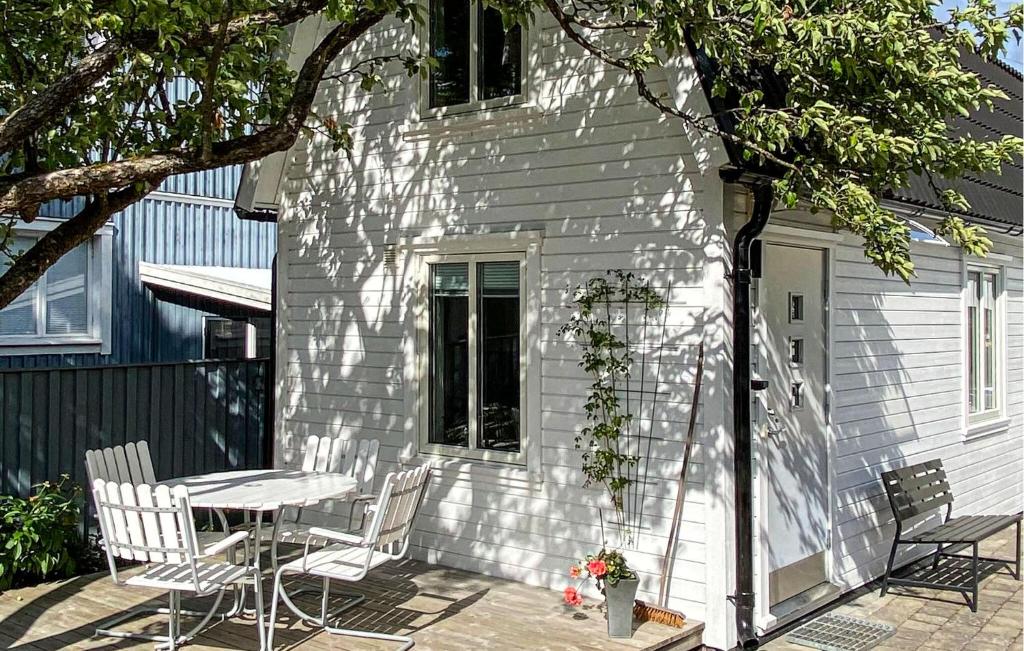 阿灵索斯Beautiful Home In Alingss With Wifi的白色的房子,在庭院配有桌椅