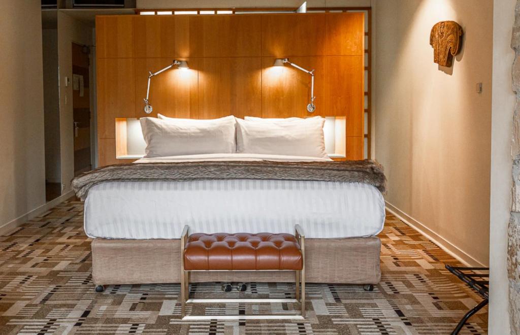 霍巴特Islington Hobart - Garden Suite - Australia的一间卧室配有一张大床和一把椅子