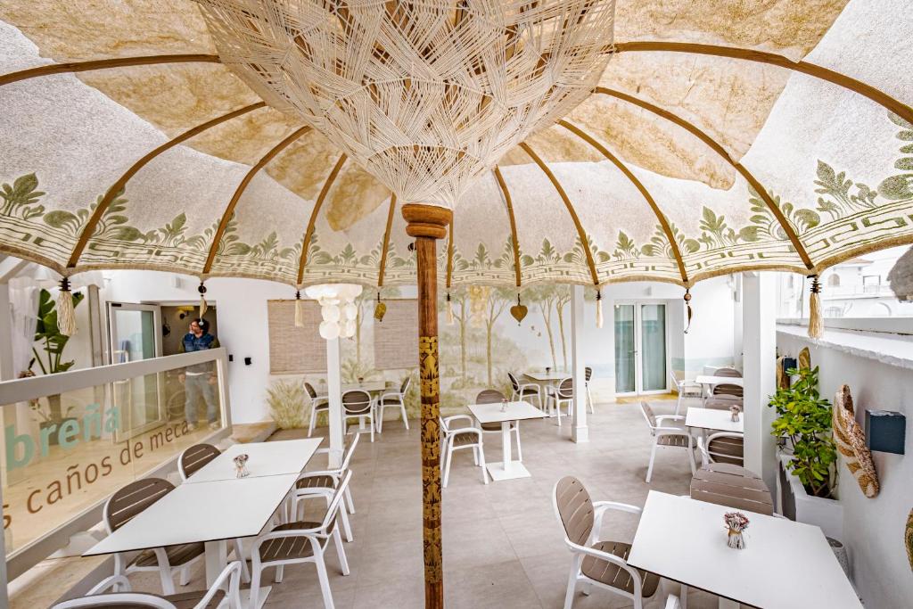 洛斯卡尼奥斯德梅卡Escondite de Noah Grupo labreña的餐厅拥有带桌椅的大型天花板。