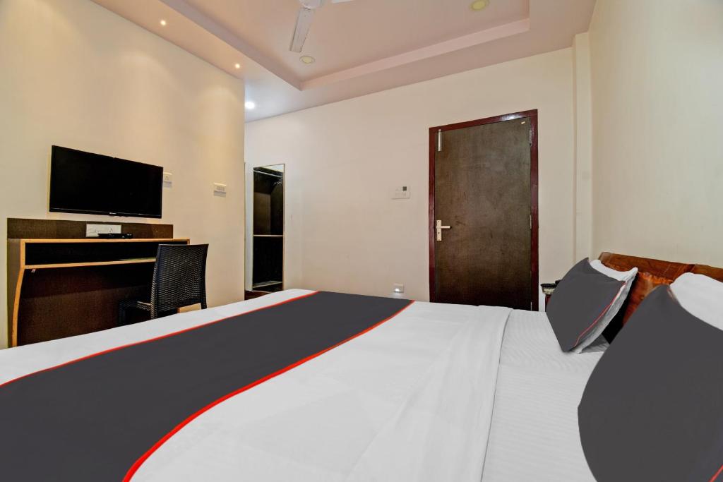 BhutiāgāonCollection O The Grand Megha Resort的酒店客房设有一张大床和一台电视。