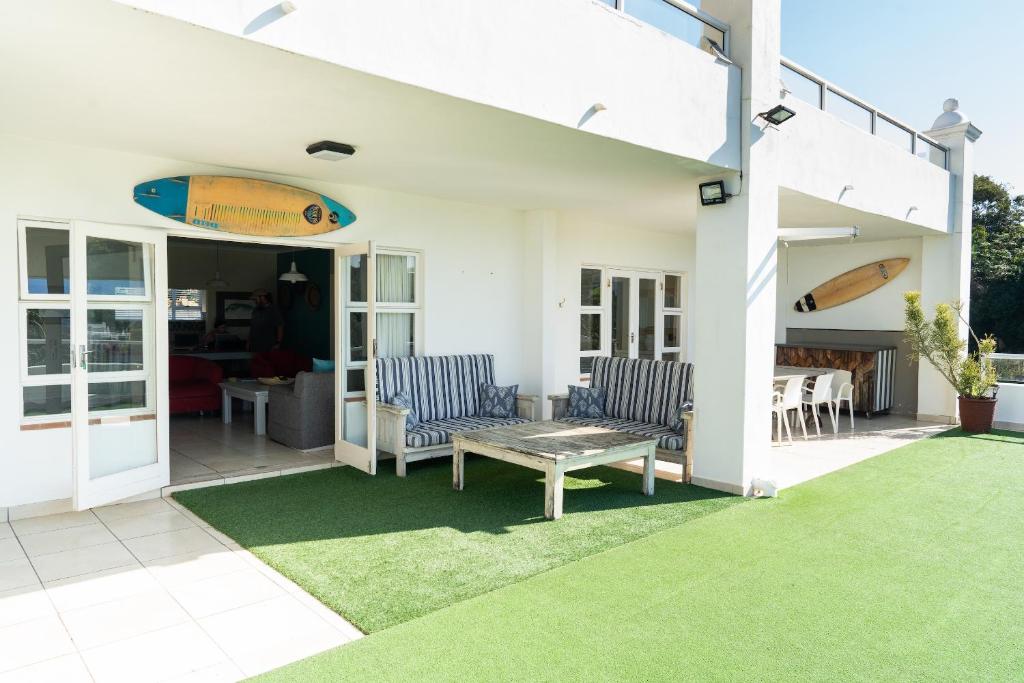 爱德华港Villa 43, The Estuary Country Estate, Port Edward, KZN South Coast的天井配有两把椅子和一张带冲浪板的桌子