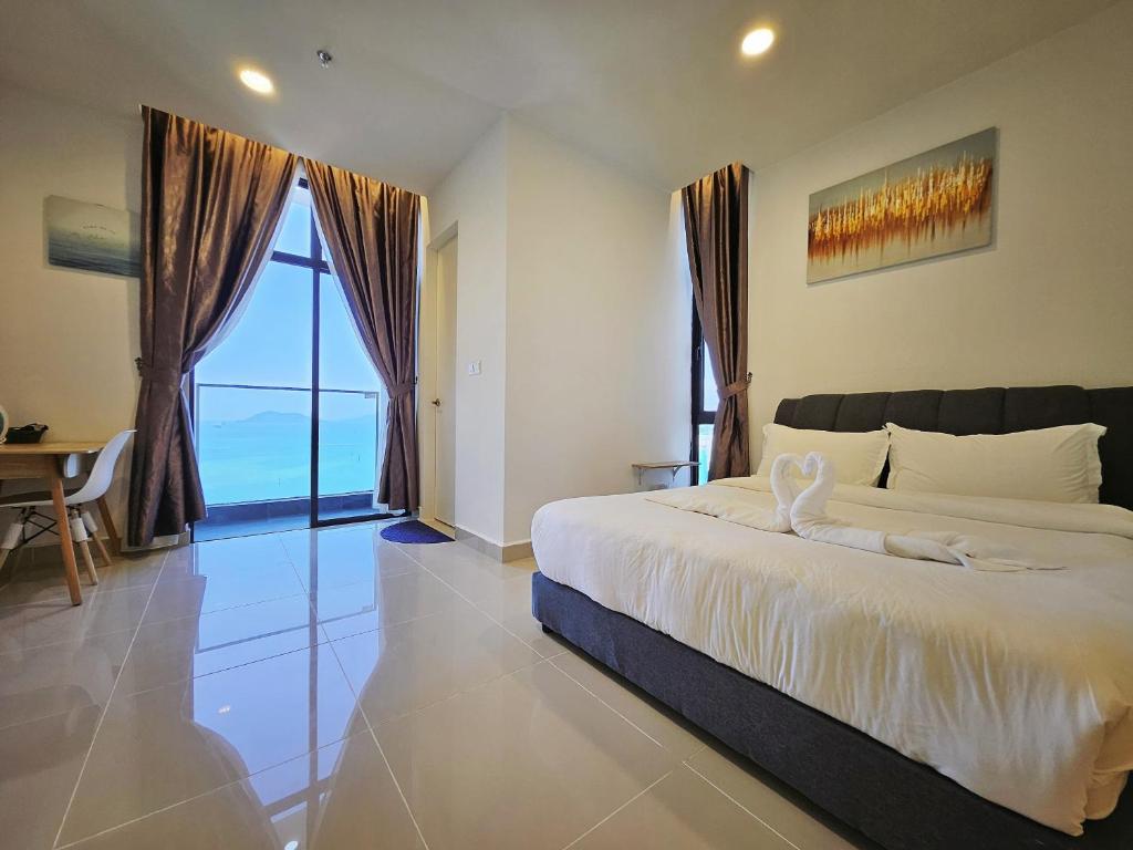 哥打京那巴鲁Summer Seaview Studio Apartment at Kota Kinabalu City Centre的一间卧室设有一张大床和一个大窗户