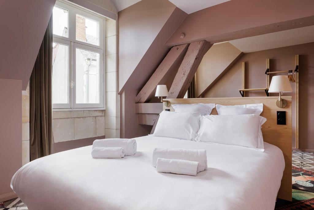 奥尔良La Loge Gogaille - Cloître - Accès autonome的一张白色的大床,带两条毛巾
