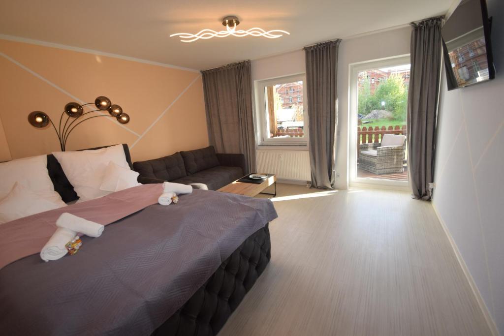 马格德堡Bliss Place - 1R Premium Apartment - Kingsize Bett, Smart TV, Küche, Balkon, Waschkeller的一间卧室配有一张床、一张沙发和一个窗口