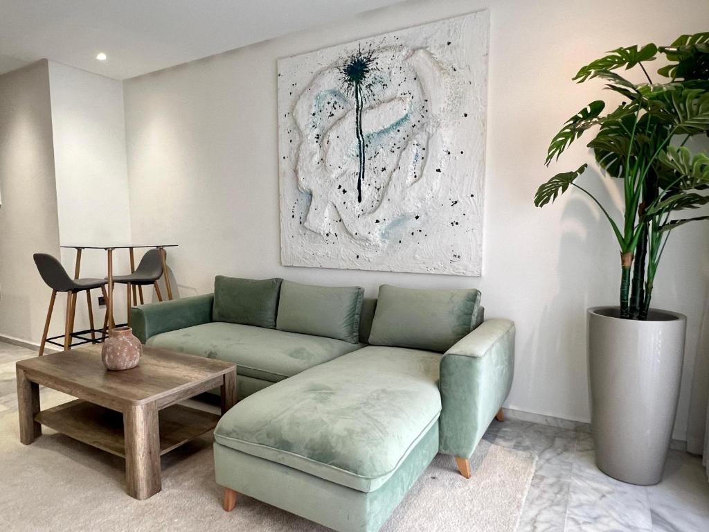 卡萨布兰卡Dynasty Estate - Maarif residency的客厅配有绿色沙发和桌子