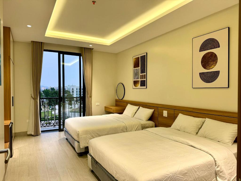岑山MARIS HOTEL SẦM SƠN的酒店客房设有两张床和一个阳台。