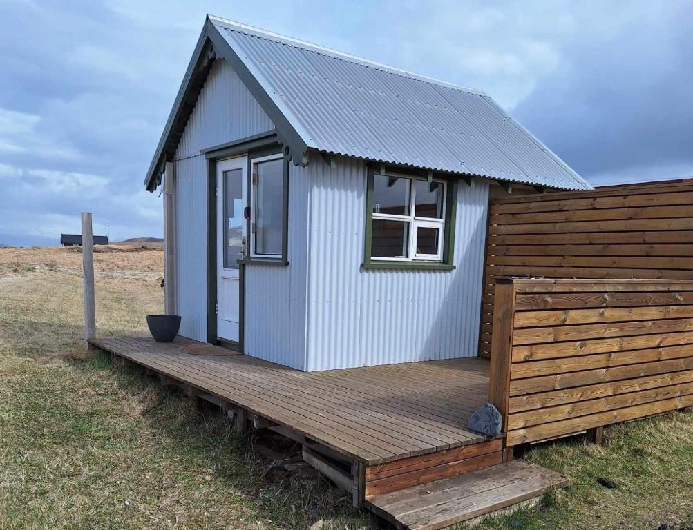 韦斯特曼纳埃亚尔Ofanleiti Cottages的田野木甲板上的一个小房子