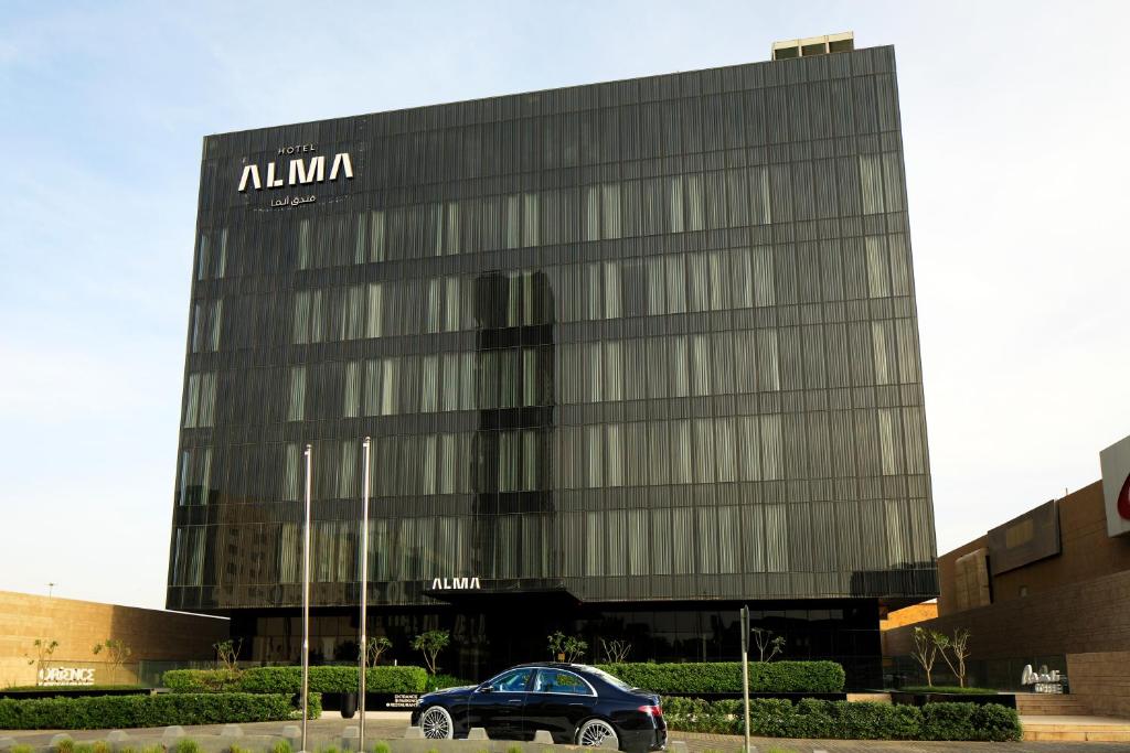 利雅德Alma Hotel的停在大楼前的汽车