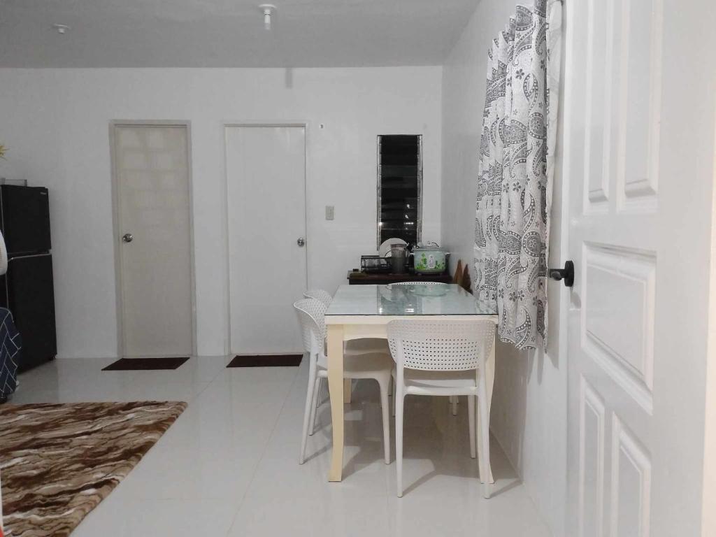 帕加迪安tadzmahal home的白色的厨房配有桌子和白色椅子