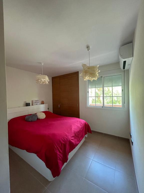滨海罗克塔斯Apartamento Aguadulce的一间卧室设有红色的床和窗户。