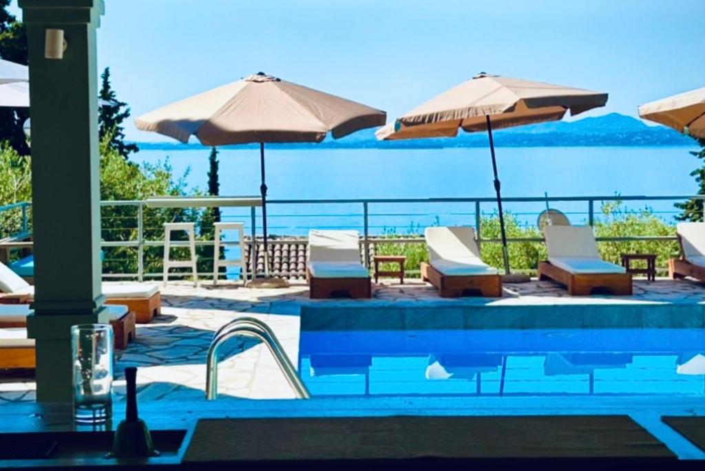 巴尔巴蒂Hotel Barbati Sea View B&B的一个带椅子和遮阳伞的游泳池