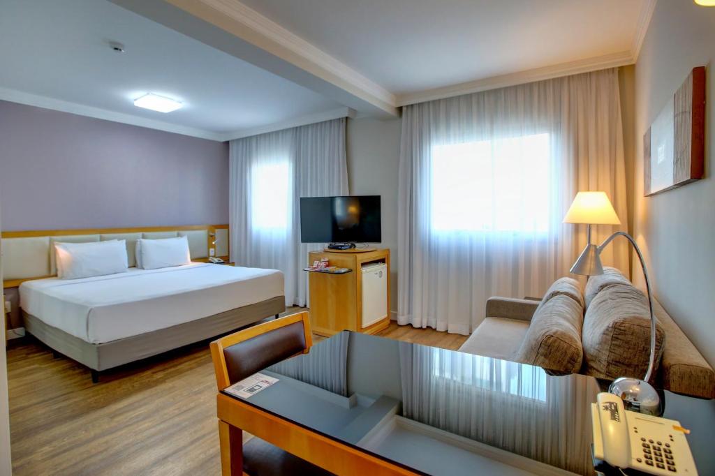 圣保罗Quality Suítes Oscar Freire的酒店客房,配有床和沙发
