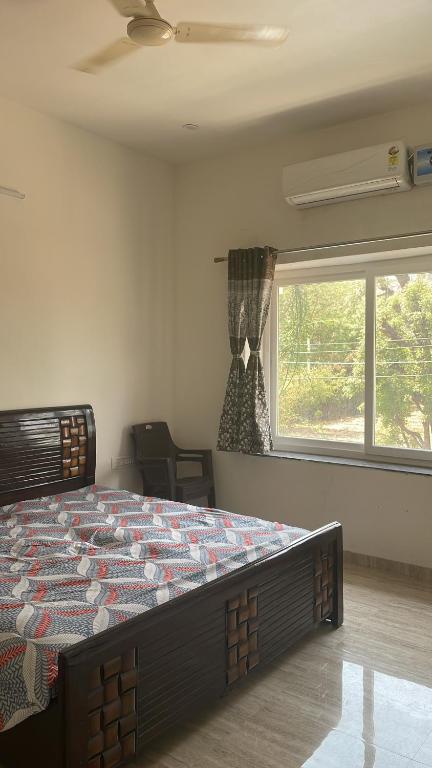 乌代浦Sai udaipur home stay的一间带一张大床的卧室,位于带窗户的房间内