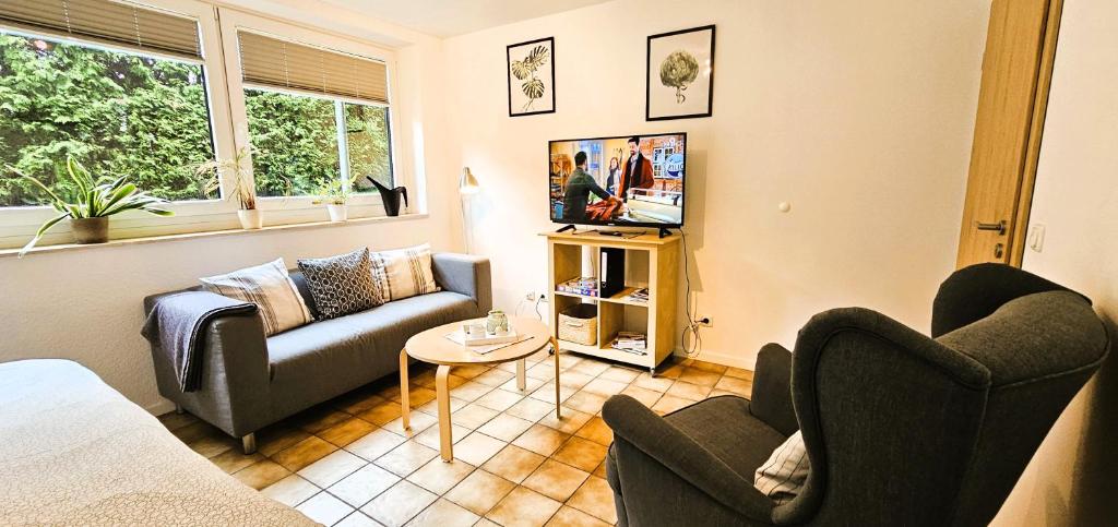 GlüsingenFerienwohnung Seevetal的客厅配有两张沙发和一台电视机