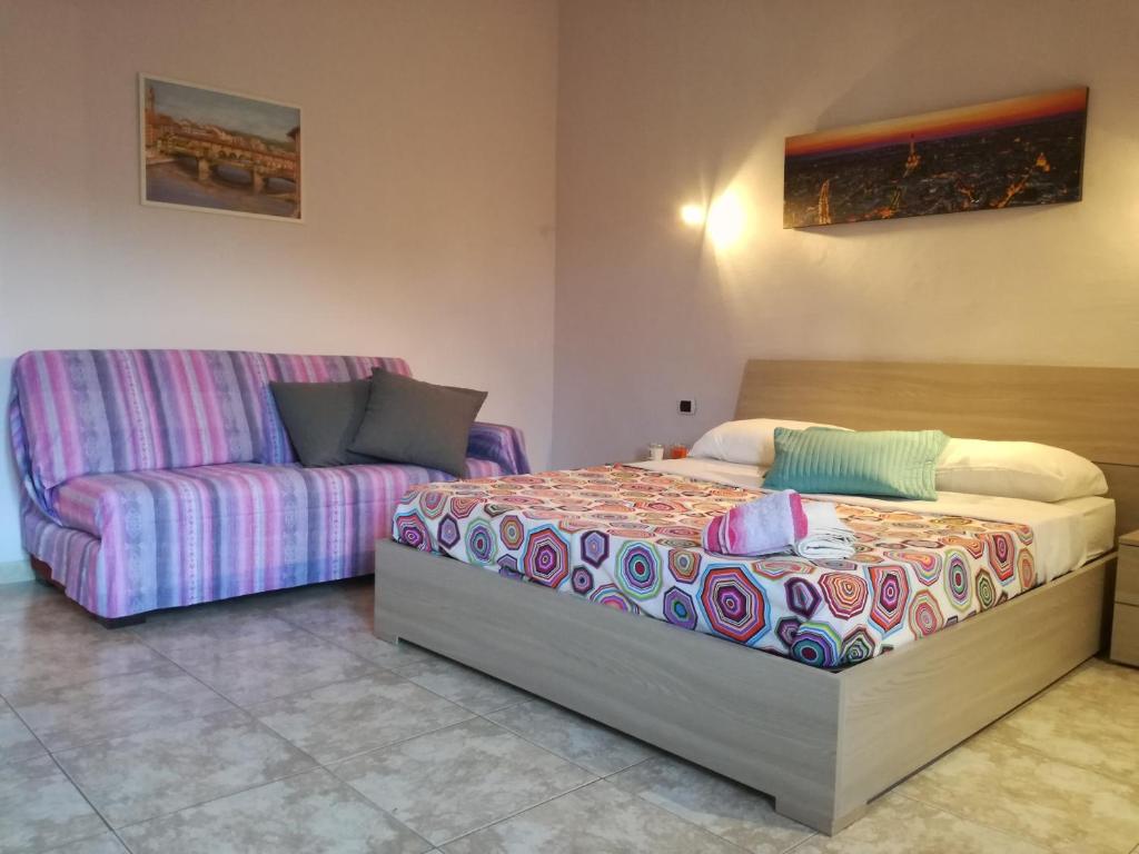 锡尼亚Home Signa Via Roma 26的一间卧室配有一张床和一张沙发