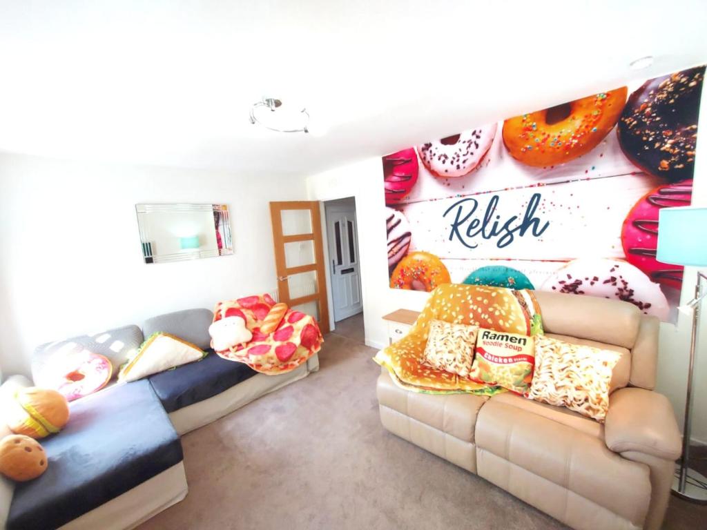 拉格斯The Relish - ground floor flat in Largs的客厅设有两张沙发和带甜甜圈的墙壁