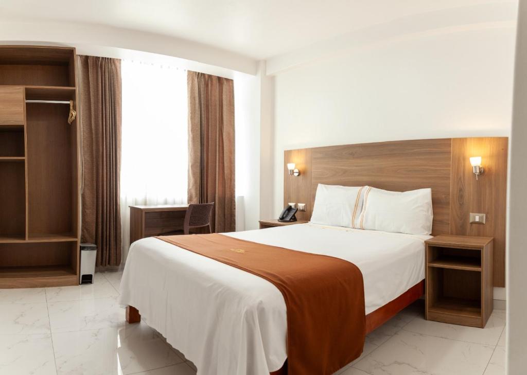 莫克瓜Las Torres Hotel Boutique的一间设有大床和窗户的酒店客房
